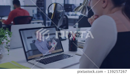 Watching woman joining online meeting at open-plan office, with laptop, pencil holder, copy space 139257267