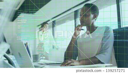 Reviewing code overlay on monitor mid adult analyst sitting at office with laptop, copy space Reviewing code overlay on monitor mid adult analyst sitting at office with laptop, copy space 139257271