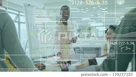 Presenting mid adult man leading discussion at whiteboard by conference table, with data overlays 139257283