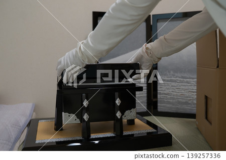A hand in a white glove touches a black lacquered box. A hand in a white glove touches a black lacquered box. 139257336