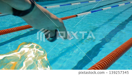 Diving athletic male swimmer entering competition pool, with red white blue lane ropes, copy space Diving athletic male swimmer entering competition pool, with red white blue lane ropes, copy space 139257345