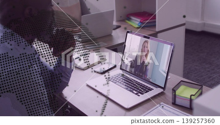 Mature man leaning at office cubicle, joining call with two laptops smartphone notebook binders Mature man leaning at office cubicle, joining call with two laptops smartphone notebook binders 139257360