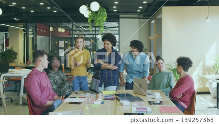 Seven office professionals collaborating around conference table in office, with laptops Seven office professionals collaborating around conference table in office, with laptops 139257363