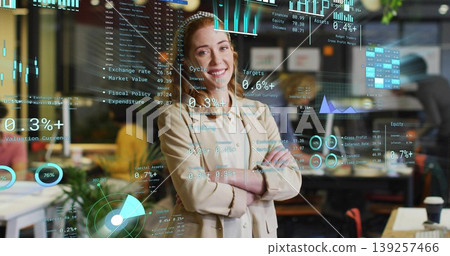 Standing central Asian woman crossing arms and smiling in open-plan office, HUD charts overlaying Standing central Asian woman crossing arms and smiling in open-plan office, HUD charts overlaying 139257466