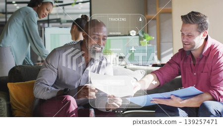 Examining two men collaborating on documents with blue clipboard in office lounge, with AR overlay Examining two men collaborating on documents with blue clipboard in office lounge, with AR overlay 139257471