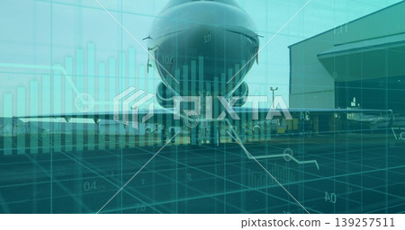 Showing airliner on airport ramp beside maintenance hangar, with baggage carts and digital overlay 139257511