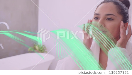 Indian woman doing facial routine in modern bathroom, with bathtub and green overlay, copy space Indian woman doing facial routine in modern bathroom, with bathtub and green overlay, copy space 139257531