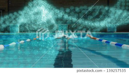 Swimmer performing front crawl in pool, with cap, goggles, briefs, lane ropes, blocks and particles 139257535