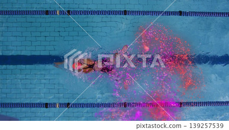 Female swimmer wearing hot pink cap and black suit gliding in pool lane, with particle trail Female swimmer wearing hot pink cap and black suit gliding in pool lane, with particle trail 139257539