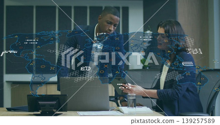 Business colleagues examining digital world map overlay in conference room, with laptop and papers Business colleagues examining digital world map overlay in conference room, with laptop and papers 139257589