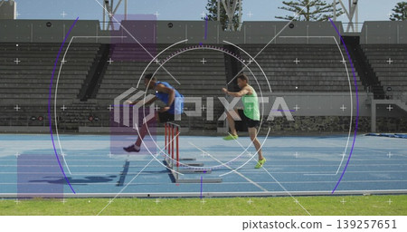 Jumping male track athletes clearing red and white hurdles on bright blue track with green turf Jumping male track athletes clearing red and white hurdles on bright blue track with green turf 139257651