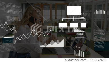 Speaking executive holding smartphone in office, with laptop notebook pen holder plant data overlay Speaking executive holding smartphone in office, with laptop notebook pen holder plant data overlay 139257698