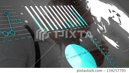 Standing man in shirt and suspenders analyzing charts on digital interface in lab, holding tablet Standing man in shirt and suspenders analyzing charts on digital interface in lab, holding tablet 139257705