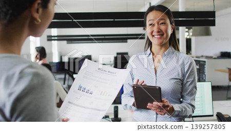 Holding tablet and receiving printed report, Korean wearing light blue shirt in office, copy space Holding tablet and receiving printed report, Korean wearing light blue shirt in office, copy space 139257805