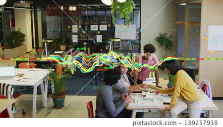 Examining four designers pointing at model at table in office, with blueprints and digital overlays Examining four designers pointing at model at table in office, with blueprints and digital overlays 139257938