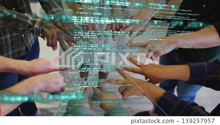 Pointing engineers' arms converging on floating code display in office area, with hologram lines Pointing engineers' arms converging on floating code display in office area, with hologram lines 139257957