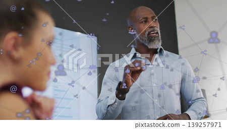 Gesturing business presenter explaining data on screen in office, with pen and network overlay Gesturing business presenter explaining data on screen in office, with pen and network overlay 139257971