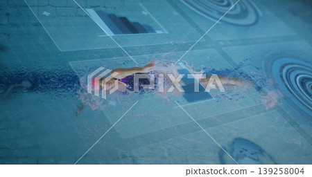 Female swimmer gliding in training pool lane with pink cap, goggles, swimsuit and digital overlays Female swimmer gliding in training pool lane with pink cap, goggles, swimsuit and digital overlays 139258004