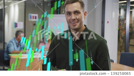 Presenting man in green shirt analyzing floating teal stock charts on partition in meeting room 139258065