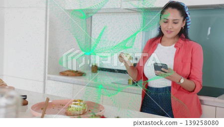 Preparing snack Indian woman at kitchen countertop with smartphone and avocado toast, copy space Preparing snack Indian woman at kitchen countertop with smartphone and avocado toast, copy space 139258080
