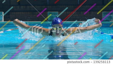 Swimming athlete performing butterfly stroke inside pool, with swimsuit, cap, goggles, overlay bars 139258113
