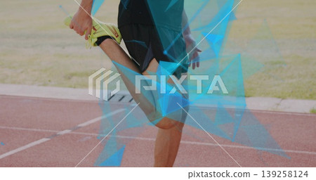 Stretching male athlete pulling foot toward buttock on red running track, neon yellow shoes Stretching male athlete pulling foot toward buttock on red running track, neon yellow shoes 139258124