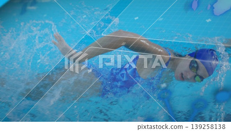 Gliding female athlete wearing blue swimsuit and cap underwater in pool, with digital overlay Gliding female athlete wearing blue swimsuit and cap underwater in pool, with digital overlay 139258138