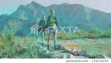 Walking two hikers carrying backpacks, wearing boots in arid foothills with reinforced trail 139258293