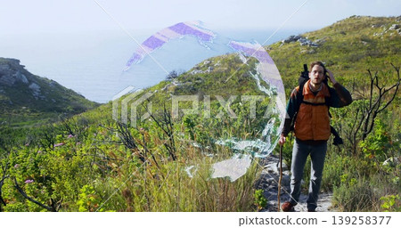 Standing adult man talking on smartphone on coastal trail, with backpack, trekking pole, copy space Standing adult man talking on smartphone on coastal trail, with backpack, trekking pole, copy space 139258377