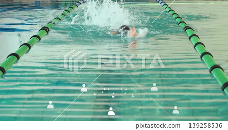 Swimming swimmer wearing swimsuit and goggles performing front crawl in lap pool, green dividers Swimming swimmer wearing swimsuit and goggles performing front crawl in lap pool, green dividers 139258536