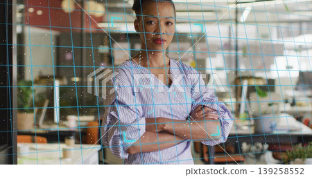 Posing African American wearing striped blouse folding arms in open office showing grid overlay Posing African American wearing striped blouse folding arms in open office showing grid overlay 139258552