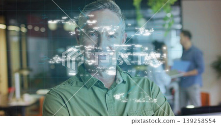 Displaying holographic data overlay, lead wearing green shirt in open office with laptop, folder Displaying holographic data overlay, lead wearing green shirt in open office with laptop, folder 139258554