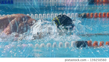 Athlete wearing black cap goggles performing front crawl in pool lane with lane dividers, splashes Athlete wearing black cap goggles performing front crawl in pool lane with lane dividers, splashes 139258560