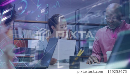 Pointing senior man and ponytail woman reviewing document at office table, with laptops and coffee Pointing senior man and ponytail woman reviewing document at office table, with laptops and coffee 139258673