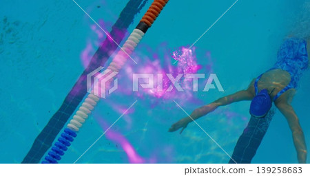 Gliding swimmer in blue swimsuit and cap in marked pool lane with floating divider, copy space 139258683