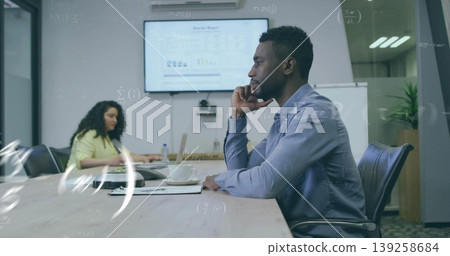 Leaning African American man analyzing charts on display in conference room with laptop, copy space 139258684
