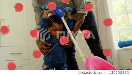 Supporting father helping baby boy pushing pink and white walker in home room near cabinets Supporting father helping baby boy pushing pink and white walker in home room near cabinets 139258823