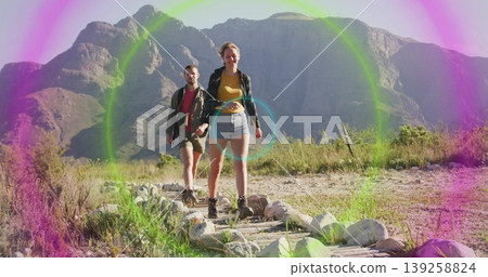 Walking couple wearing hiking boots traversing mountain trail, with logs stones shrubs lens flare Walking couple wearing hiking boots traversing mountain trail, with logs stones shrubs lens flare 139258824