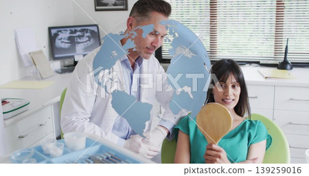 Examining dentist in lab coat adjusting hand mirror for patient in green dental chair, copy space Examining dentist in lab coat adjusting hand mirror for patient in green dental chair, copy space 139259016