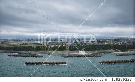 A view of the Sasagawa district and offshore wind turbines from Shimonikawa Beach in Nyuzen Town, Toyama Prefecture, during bad weather at the end of April. A view of the Sasagawa district and offshore wind turbines from Shimonikawa Beach in Nyuzen Town, Toyama Prefecture, during bad weather at the end of April. 139259228