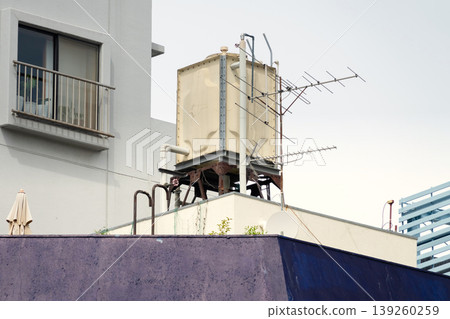 一張建築物屋頂水箱及其隨時間推移而損壞的圖片。 139260259