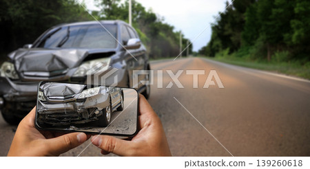 Man hands hold smartphone capturing photo of damaged car wreck after road accident with copy space, documenting vehicle crash evidence on screen for insurance claim and coverage assessment. Man hands hold smartphone capturing photo of damaged car wreck after road accident with copy space, documenting vehicle crash evidence on screen for insurance claim and coverage assessment. 139260618