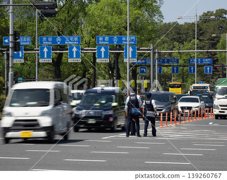A police officer directing traffic at a city intersection, and the flow of cars – an everyday scene on the road. A police officer directing traffic at a city intersection, and the flow of cars – an everyday scene on the road. 139260767