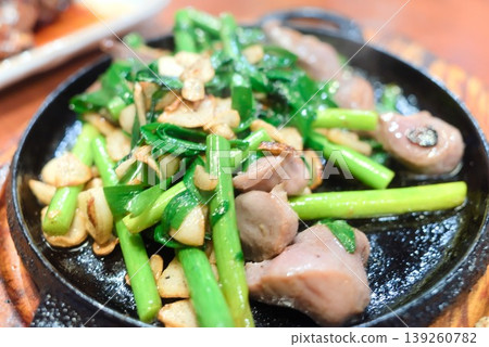 Stir-fried chives and chicken gizzards served on a hot plate. Stir-fried chives and chicken gizzards served on a hot plate. 139260782