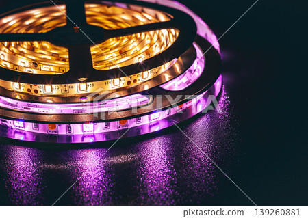 LED strip lights glowing with colorful illumination on dark background, modern lighting technology LED strip lights glowing with colorful illumination on dark background, modern lighting technology 139260881