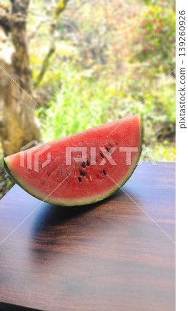冰鎮西瓜在綠色背景的襯托下,營造出夏日氣息。 冰鎮西瓜在綠色背景的襯托下,營造出夏日氣息。 139260926