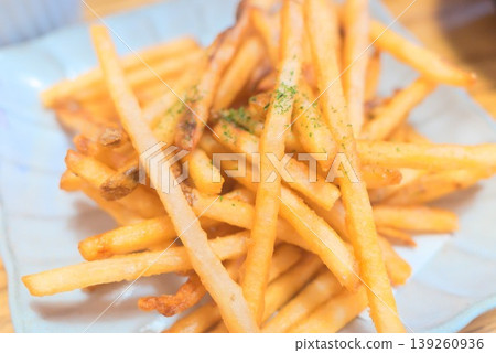 Freshly fried French fries served in a white bowl. Freshly fried French fries served in a white bowl. 139260936