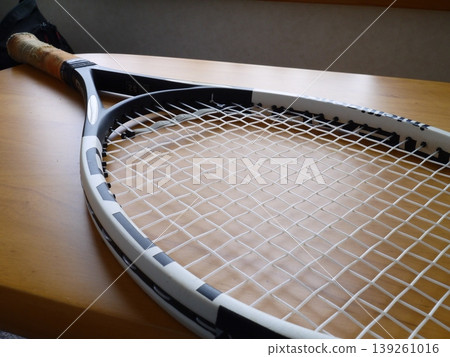 A tennis racket placed on the table 139261016
