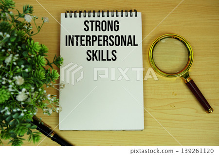 Strong Interpersonal Skills text written on notepad with magnifying glass flat lay on wooden background Strong Interpersonal Skills text written on notepad with magnifying glass flat lay on wooden background 139261120
