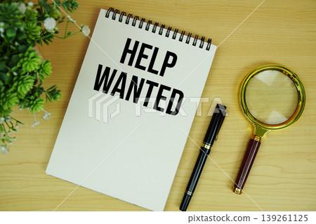 Help Wanted text written on notepad with magnifying glass flat lay on wooden background 139261125